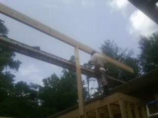 Carpenter setting a ridge beam over a new addition frame — Ice Dam Removal by Roofing Brothers in La Grange