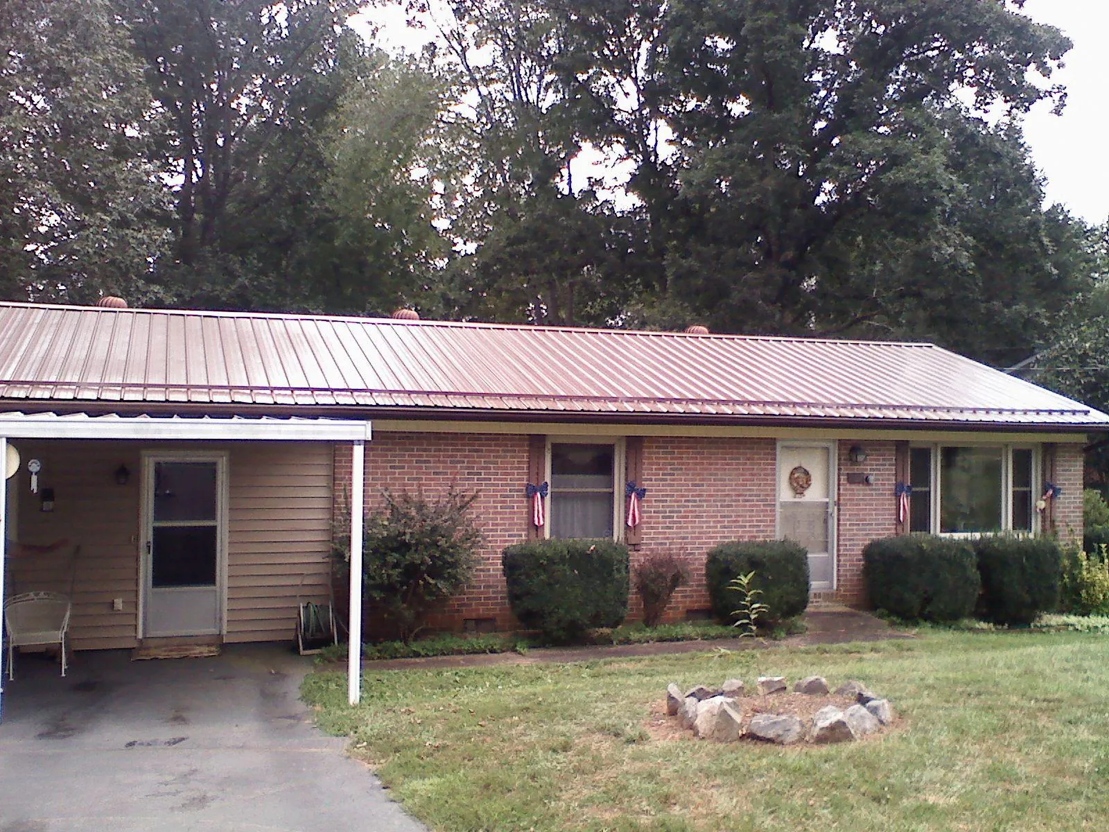 Bronze metal roof and carport on a brick ranch home — Roof Repair work by our crew in La Grange
